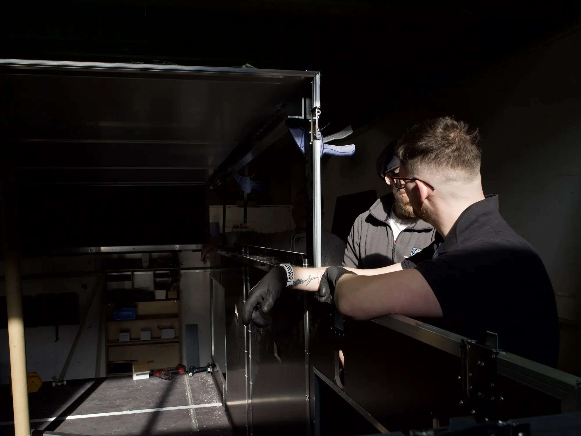 A case maker at the Absolute Casing workshop, seen through the open window of a part-built case.
