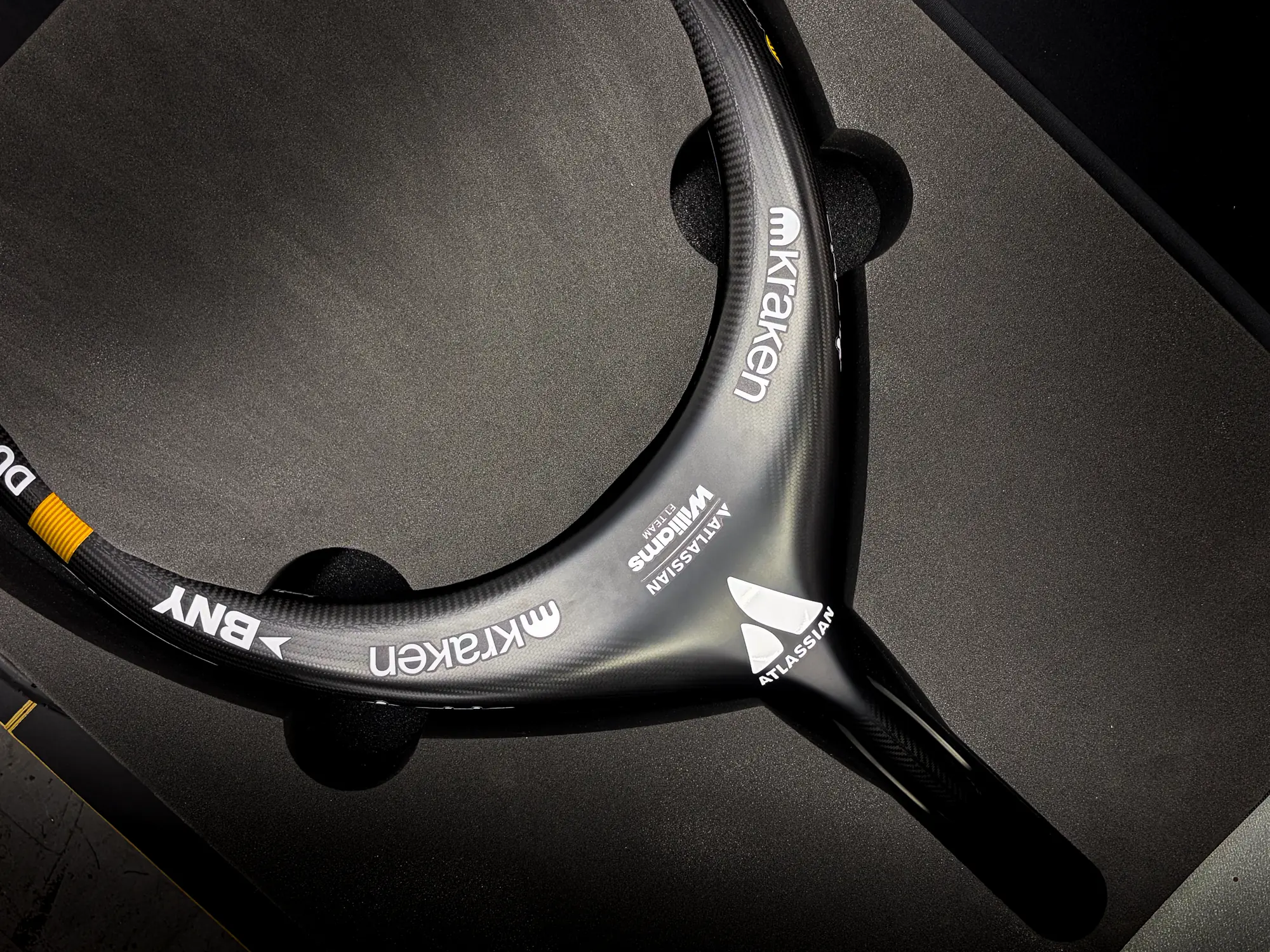 A carbon-fibre Formula 1 halo seated in a CNC-cut foam insert inside a padded protective case.
